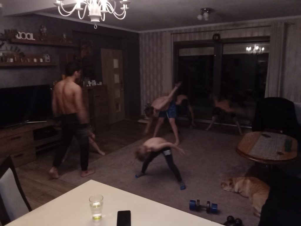 Chłopcy ćwiczą gimnastykę w salonie