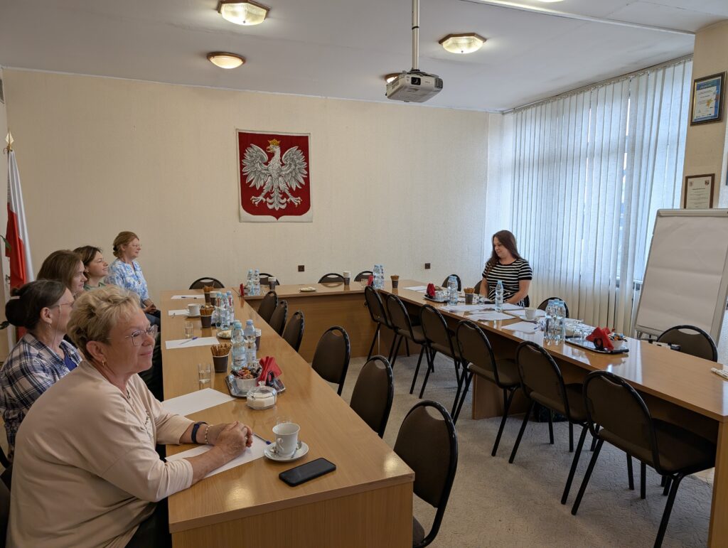 spotkanie grupowe, osoby siedzą przy stole, trwa szkolenie