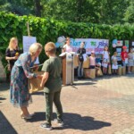 Dyrekor PCPR na scenie wręcza chłopcu nagrodę za udział w konkursie plastycznym